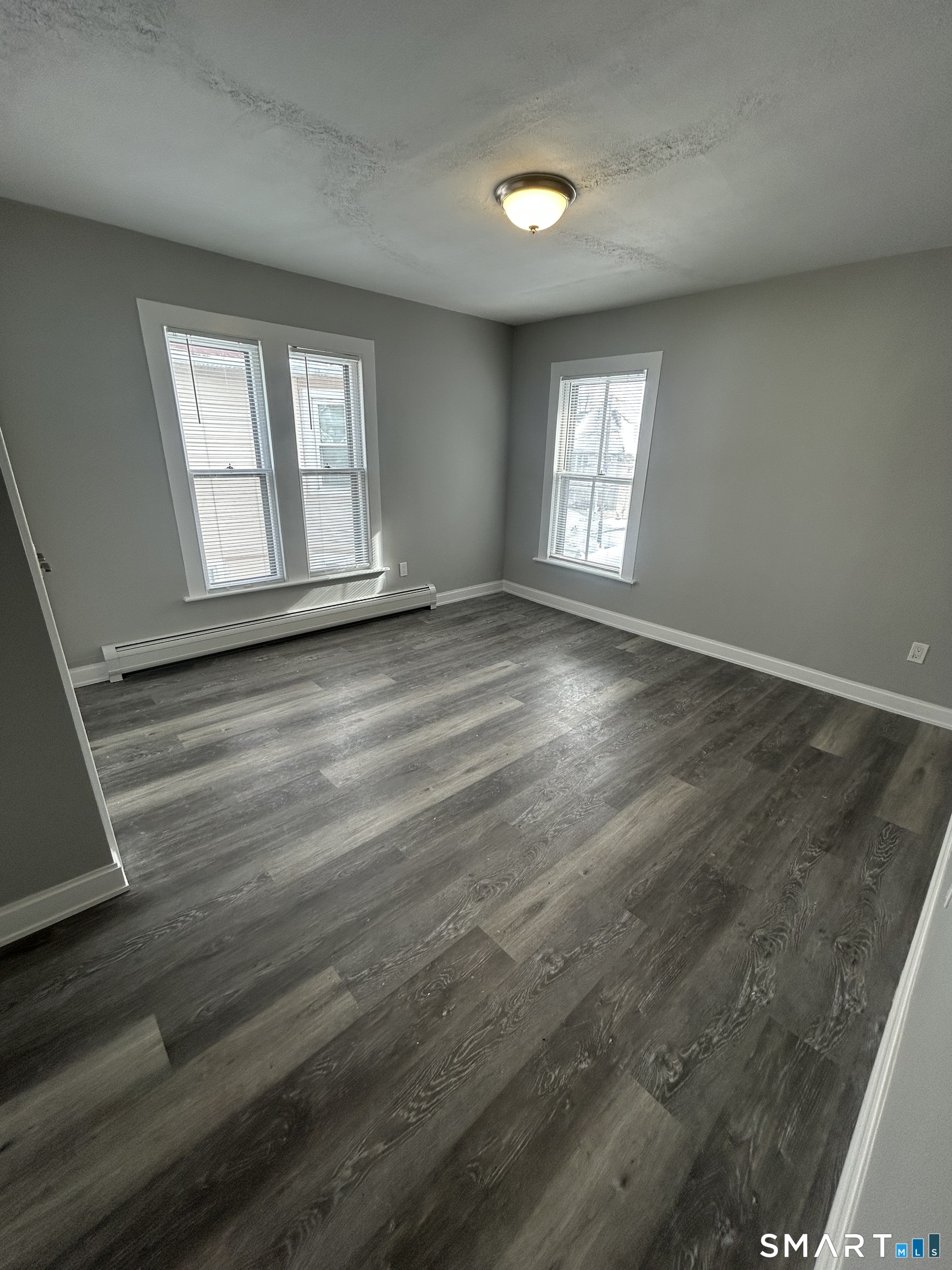 54 Forest Street, Unit 2 Torrington, CT 06790 - Photo 22 of 36 an empty room with wooden floor and windows