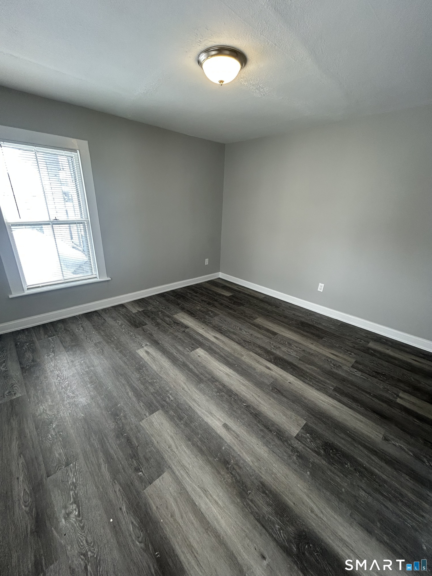 54 Forest Street, Unit 2 Torrington, CT 06790 - Photo 23 of 36 an empty room with wooden floor and windows