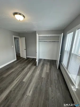 a view of empty room with wooden floor