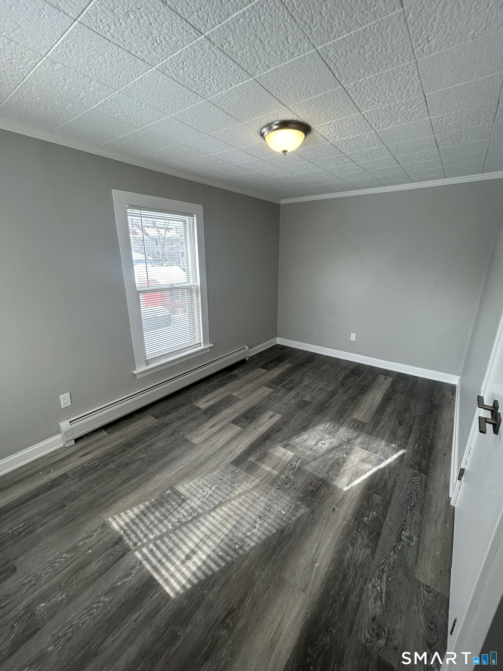 54 Forest Street, Unit 2 Torrington, CT 06790 - Photo 25 of 36 an empty room with wooden floor and windows