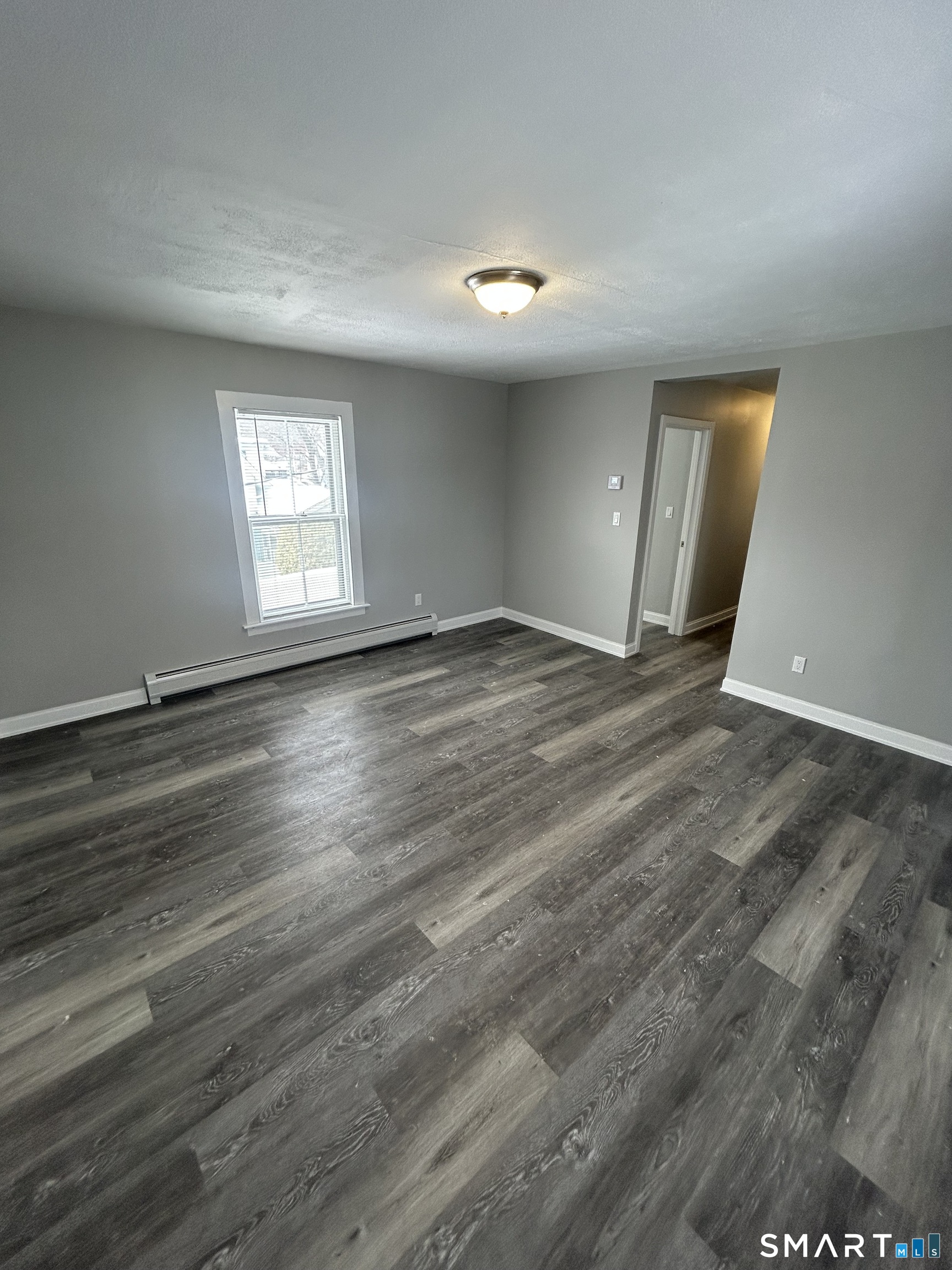 54 Forest Street, Unit 2 Torrington, CT 06790 - Photo 31 of 36 a view of an empty room with wooden floor and a window