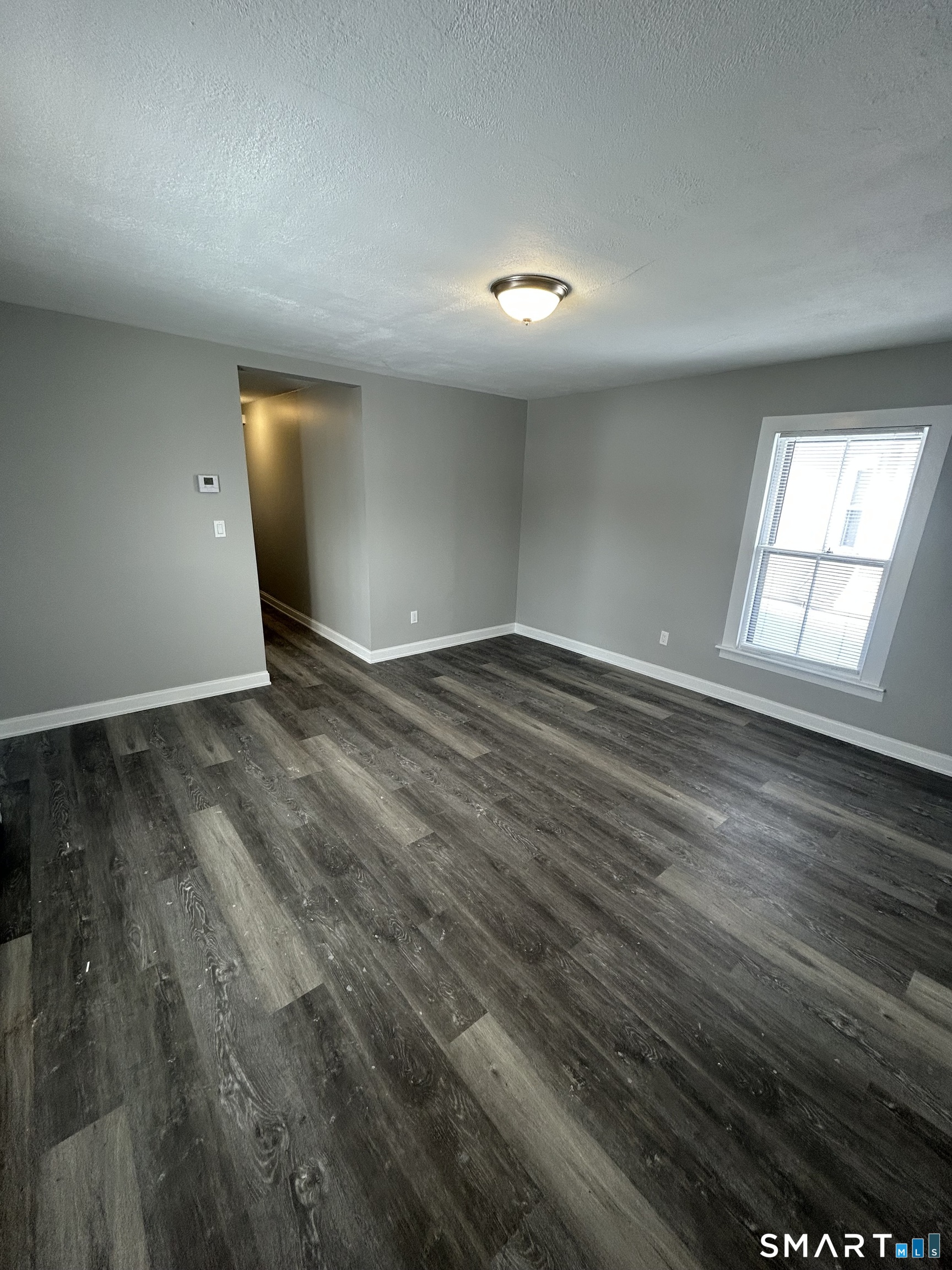 54 Forest Street, Unit 2 Torrington, CT 06790 - Photo 33 of 36 an empty room with wooden floor and windows