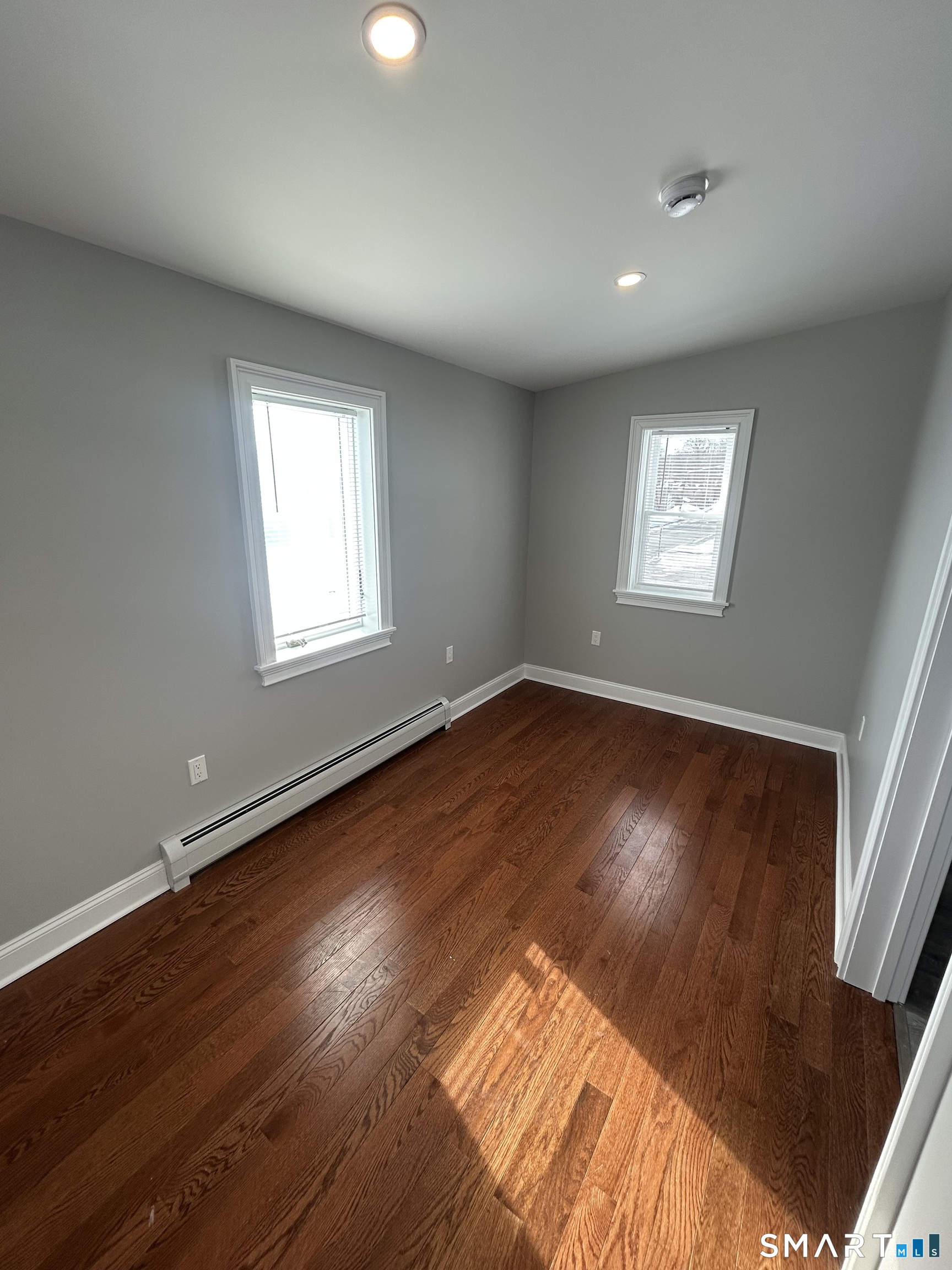 54 Forest Street, Unit 2 Torrington, CT 06790 - Photo 34 of 36 an empty room with wooden floor and windows