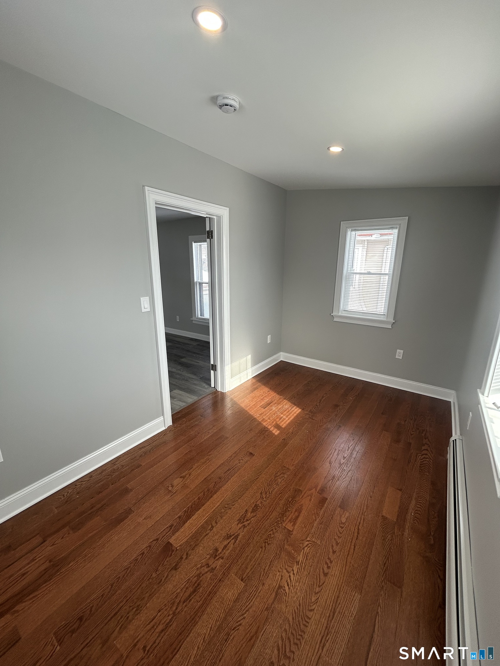 54 Forest Street, Unit 2 Torrington, CT 06790 - Photo 35 of 36 an empty room with wooden floor and windows