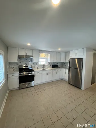 a kitchen with stainless steel appliances a refrigerator sink and cabinets