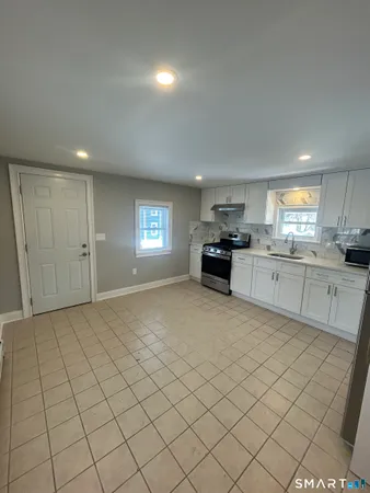 a view of kitchen with granite countertop cabinets and window