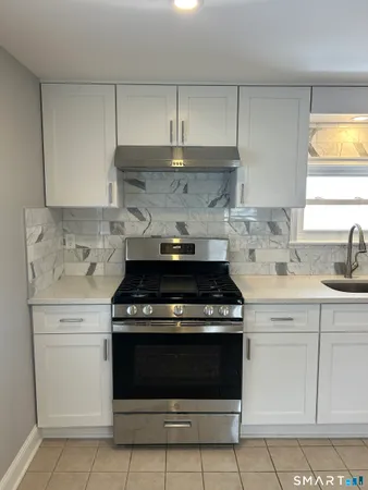 a stove top oven sitting inside of a kitchen