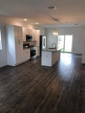 a view of kitchen with cabinets microwave and stove