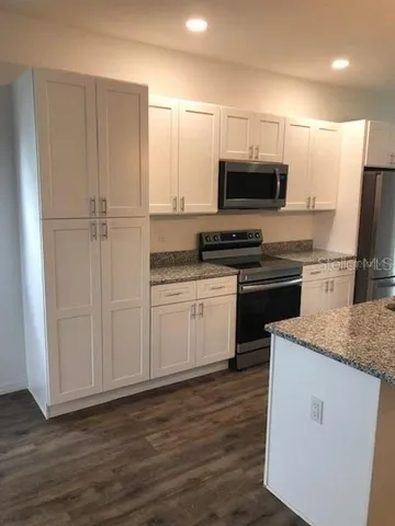 a kitchen with stainless steel appliances granite countertop a stove a sink and a refrigerator