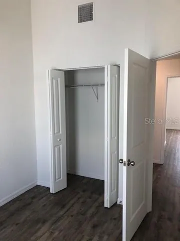 an empty room with wooden floor and closet