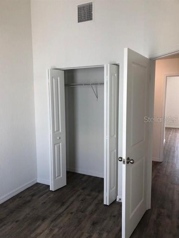 1272 Pierce Street Clearwater, FL 33756 - Photo 5 of 14 an empty room with wooden floor and closet