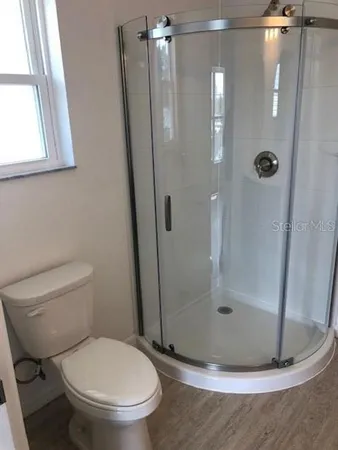 a white toilet sitting next to a shower
