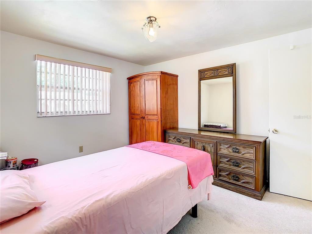 4230 Redcliff Place, Unit 4230 New Port Richey, FL 34652 - Photo 22 of 42 a bedroom with a bed and a dresser