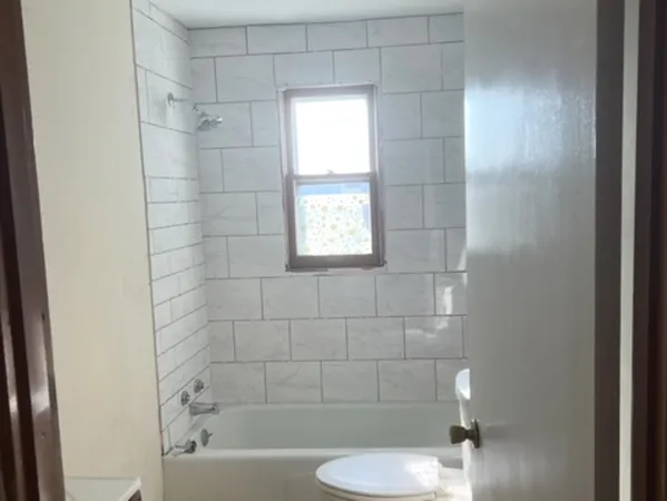 a bathroom with a bathtub a sink a toilet and shower