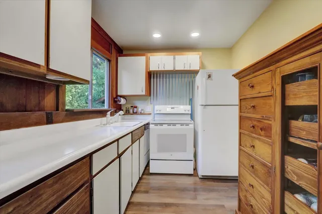 a kitchen with a sink cabinets stainless steel appliances and a window