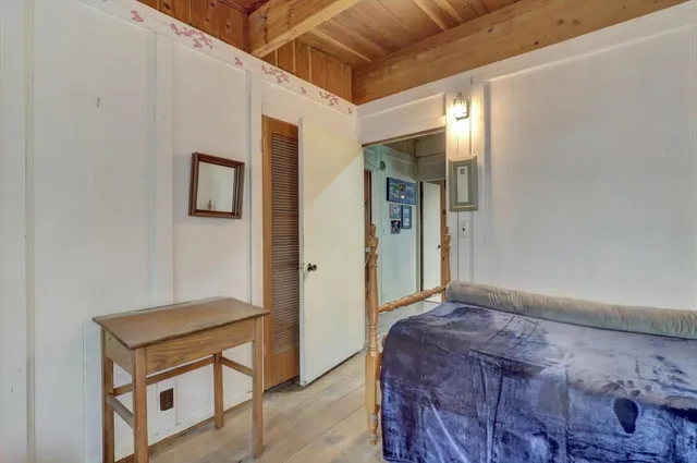 a bedroom with a bed and wooden floor