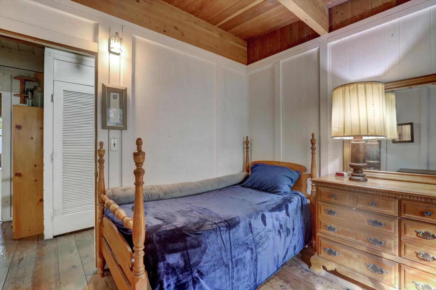 10046 Smith Road Grass Valley, CA 95949 - Photo 26 of 52 a bedroom with a bed and wooden floor