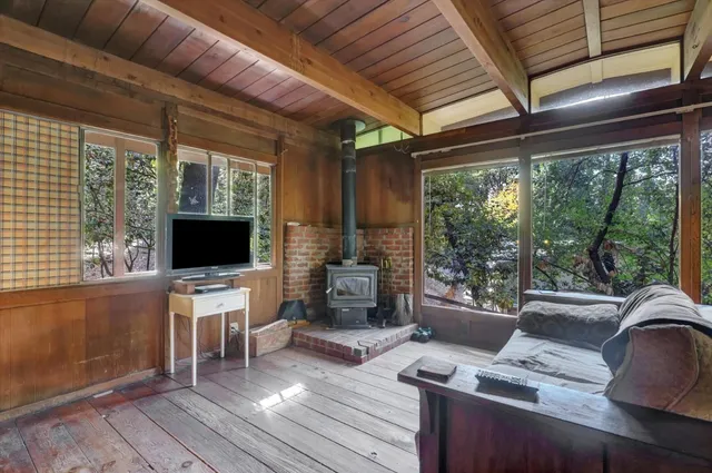 a living room with furniture a flat screen tv and a floor to ceiling window