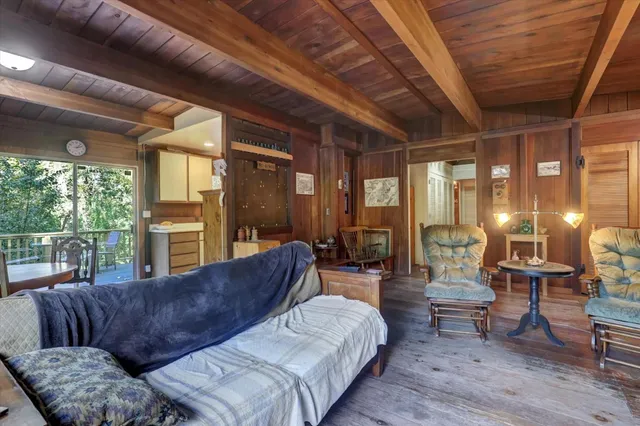 a living room with furniture a lamp wooden floor and a large window