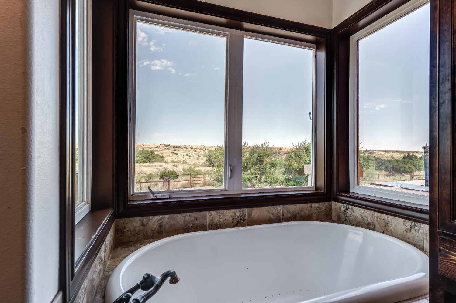 396 County Road 130 Slaton, TX 79364 - Photo 37 of 50 a bath tub sitting in a bathroom next to a window