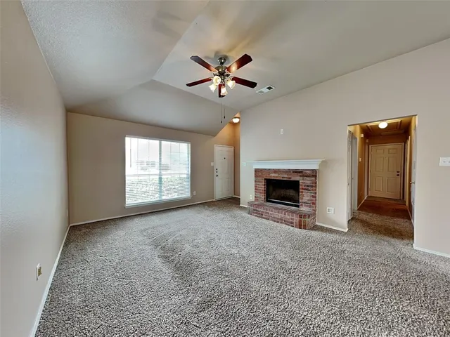 an empty room with windows and fireplace