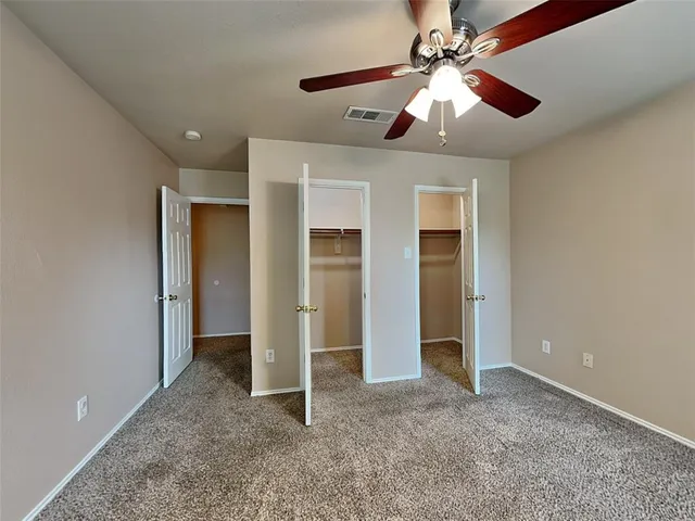 a view of an empty room with a ceiling fan
