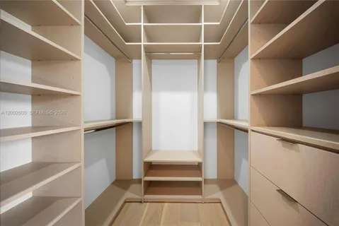 a view of a hallway with wooden floor and windows