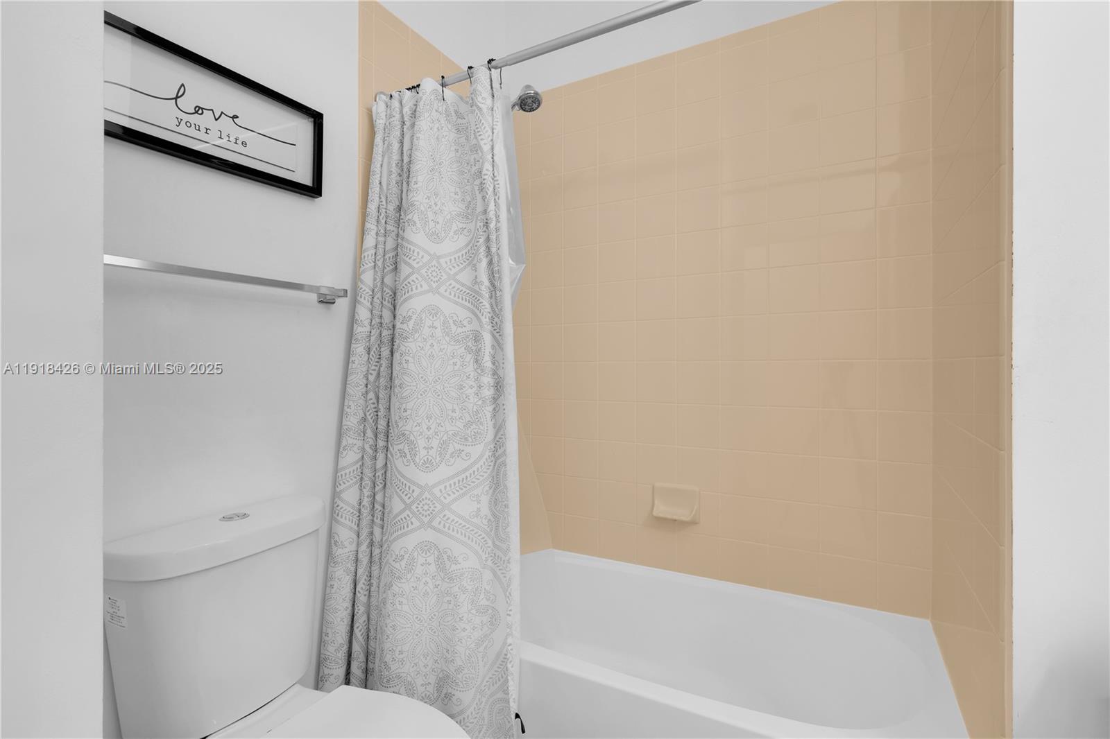 1516 Southwest 147th Avenue Pembroke Pines, FL 33027 - Photo 15 of 29 a bathroom with a shower curtain and a toilet