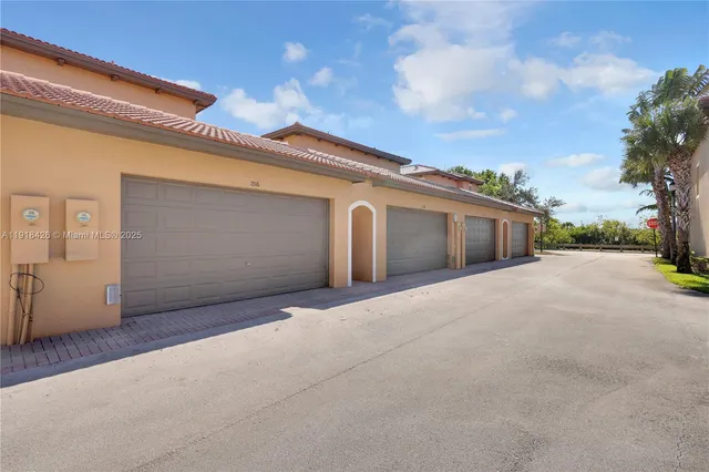 a front view of a house with a garden and trees