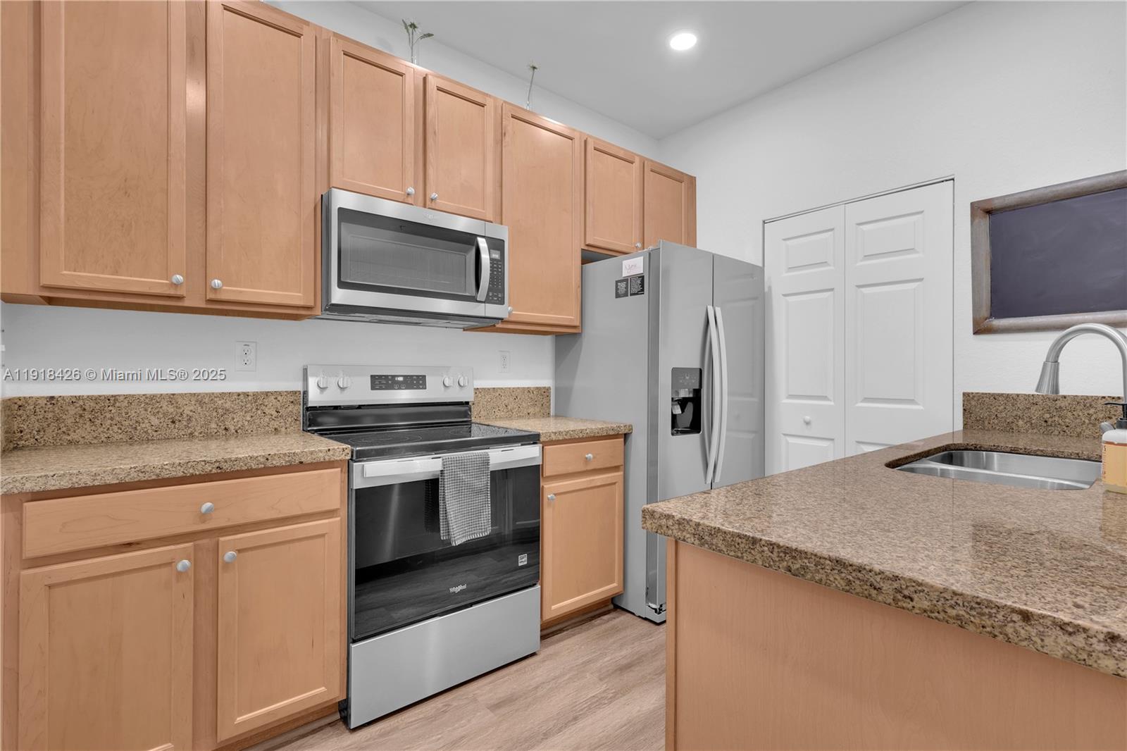 1516 Southwest 147th Avenue Pembroke Pines, FL 33027 - Photo 8 of 29 a kitchen with granite countertop wooden cabinets and stainless steel appliances