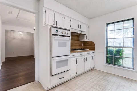a kitchen with white cabinets and white appliances