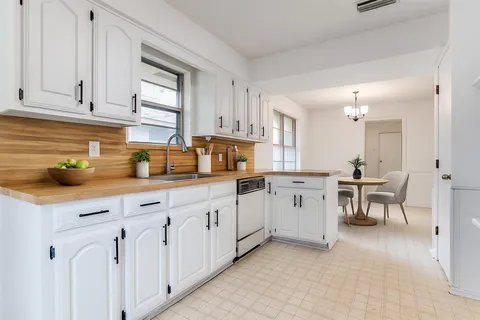 a kitchen with white cabinets and sink
