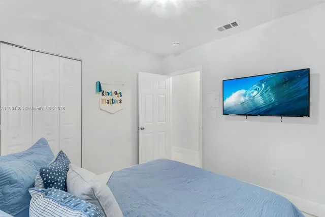 a bedroom with a bed and painting on the wall