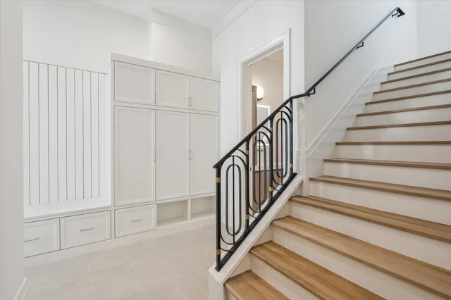 a view of staircase with white walls and a rug