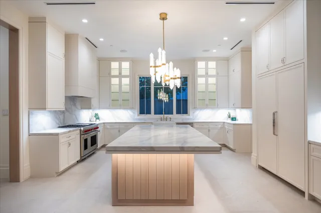 a large kitchen with stainless steel appliances granite countertop a sink a stove and a refrigerator