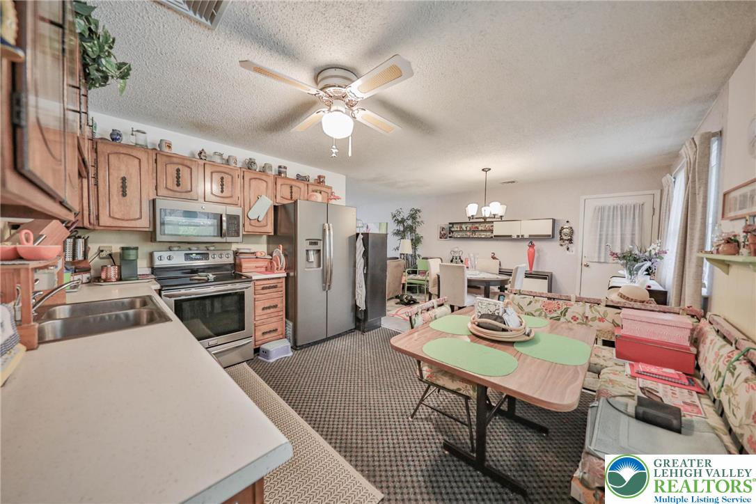 1502 2nd Street Bethlehem, PA 18020 - Photo 17 of 62 a open kitchen with stainless steel appliances kitchen island granite countertop a refrigerator a stove a microwave oven a sink with island and chairs