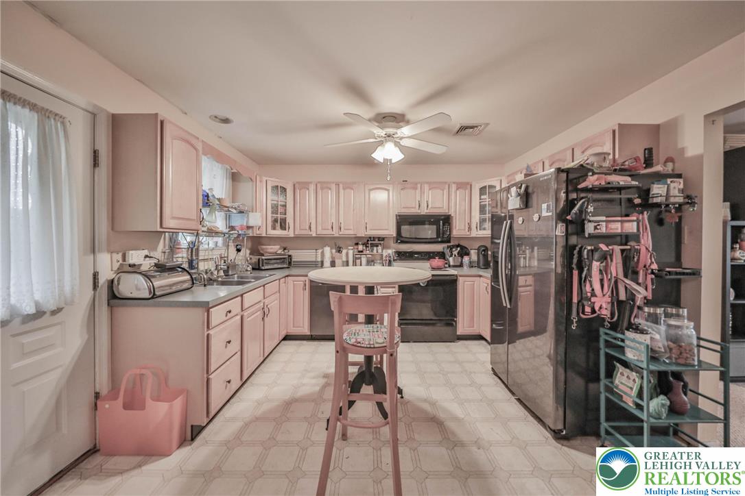1502 2nd Street Bethlehem, PA 18020 - Photo 42 of 62 a kitchen with stainless steel appliances kitchen island granite countertop a refrigerator oven a sink a dining table and chairs with the large window