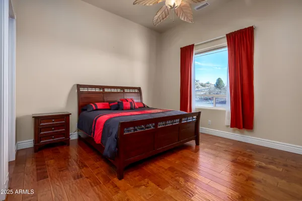 a bedroom with a bed and wooden floor
