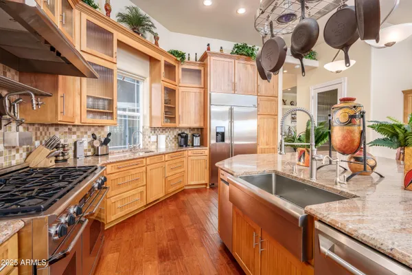 a kitchen with stainless steel appliances granite countertop a kitchen island a stove and a sink