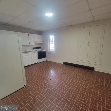 an empty room with wooden floor and cabinets