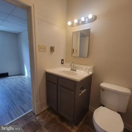 a bathroom with a sink vanity mirror and toilet