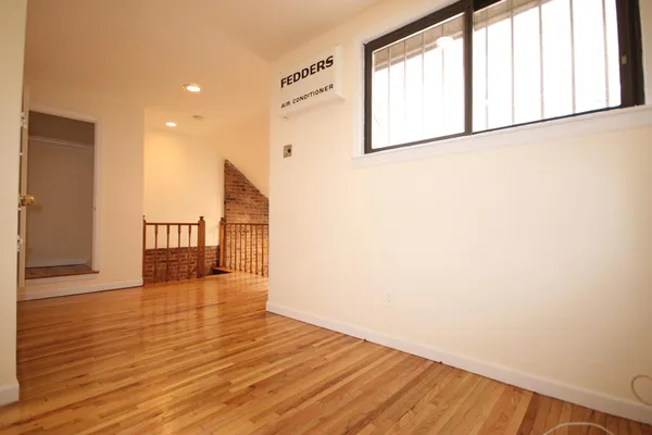 a view of empty room with wooden floor and windows
