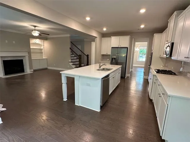 a kitchen with a stove a sink a refrigerator and a microwave