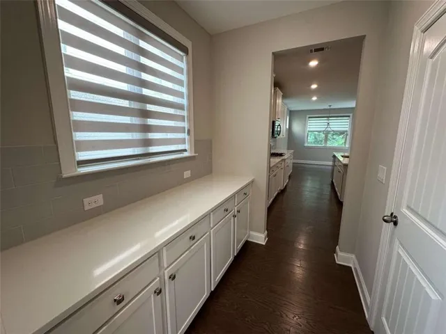 a view of a hallway with wooden floor and windows