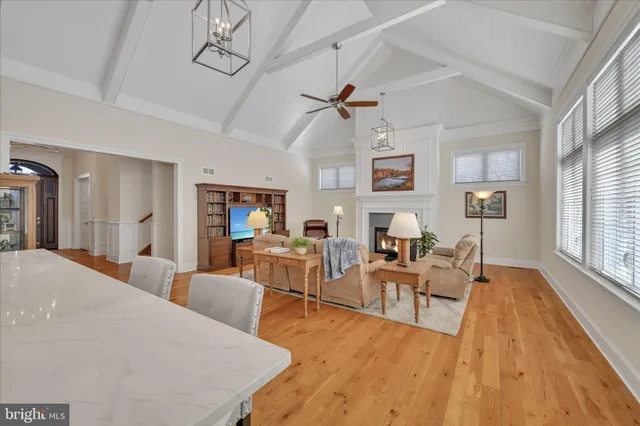 a kitchen with stainless steel appliances kitchen island granite countertop a refrigerator a stove a oven and white cabinets with wooden floor