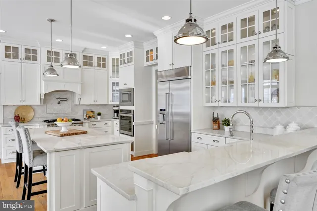 a kitchen with stainless steel appliances granite countertop a refrigerator and a stove top oven