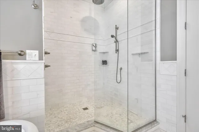 an empty room with a chandelier fan and windows