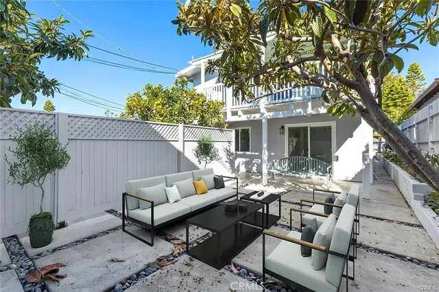 a view of a patio with couches table and chairs and potted plants