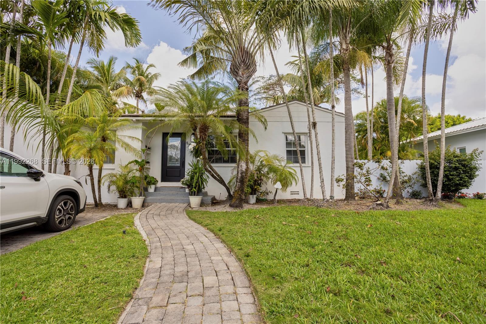 5755 Devonshire Boulevard, Unit 5755 Miami, FL 33155 - Photo 2 of 30 a view of a house with a yard and palm trees