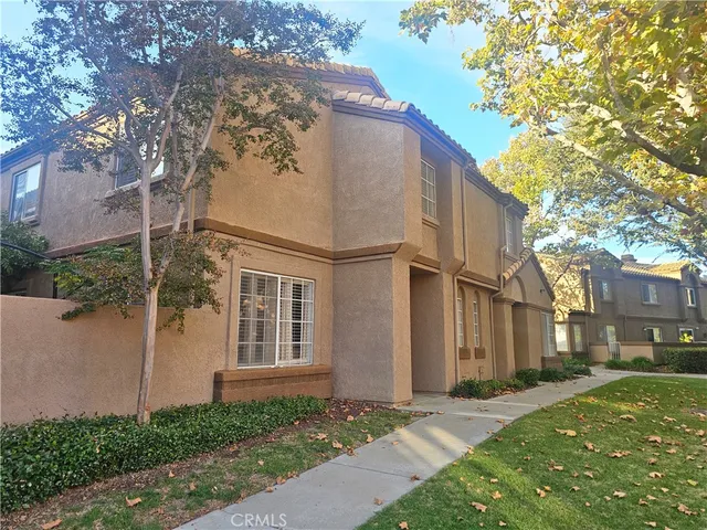 a view of a white house with a large tree